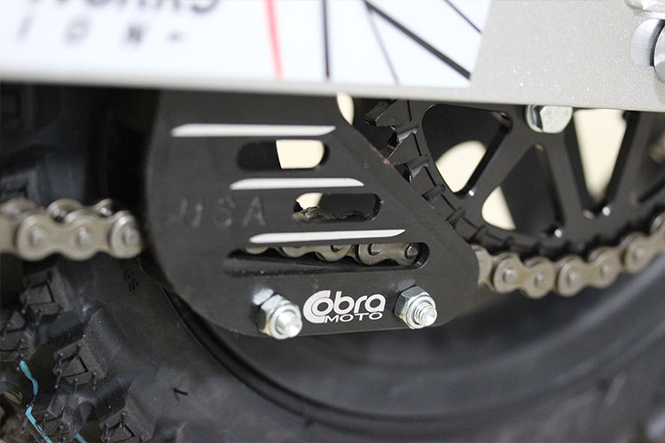 A tough chain guide keeps the chain on the sprocket in the deep big bike ruts.
